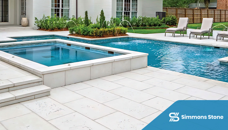 Spacious poolside patio with large pavers, fountains, and lush seating