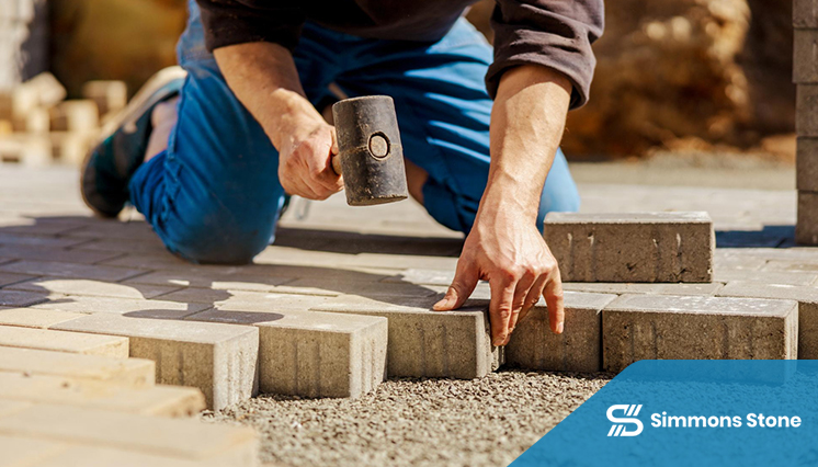 Workers installing pavers to create a durable outdoor surface