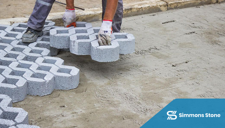 Worker installing designer pavers at a commercial location