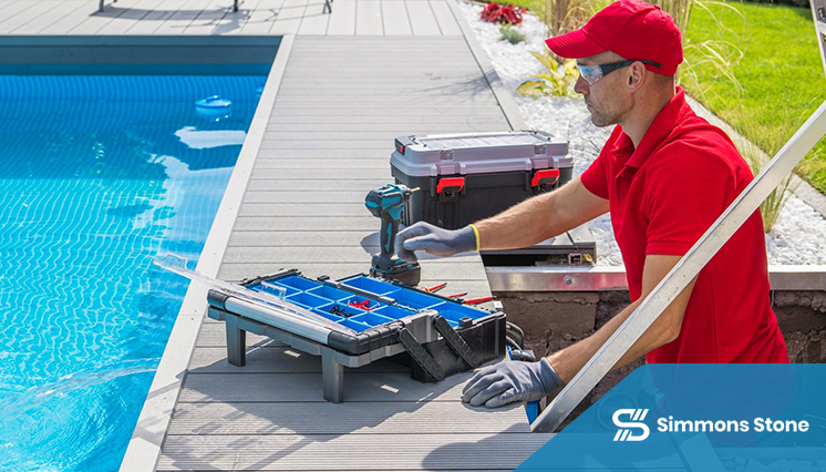 Poolside technician with gloves and toolbox for paver installation