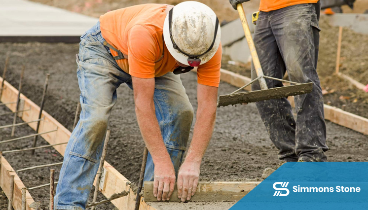 Pouring and shaping concrete curb on residential driveway