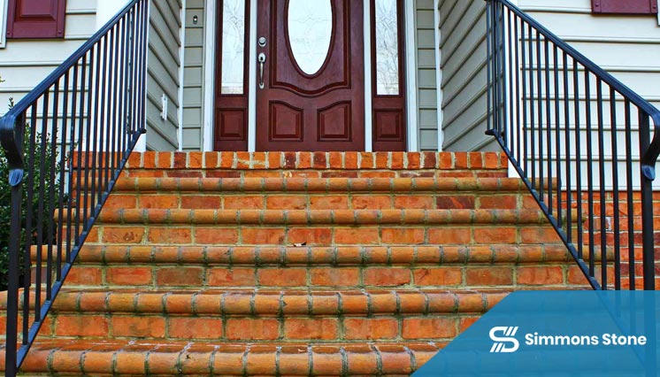 Brick steps featuring stone risers and iron handrail
